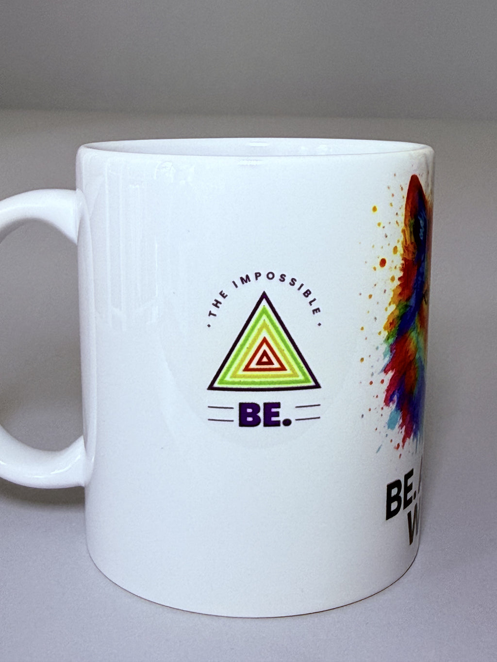 Taza “BE. THE IMPOSSIBLE” – Lobo multicolor estilo acuarela. Mensaje frontal grande