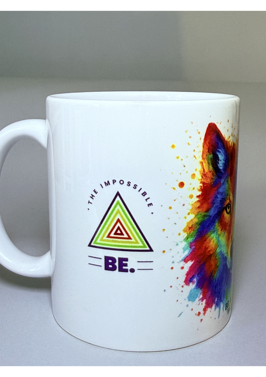 Taza “BE. THE IMPOSSIBLE” – Lobo multicolor estilo acuarela. Mensaje frontal pequeño